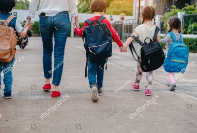 stock-photo-mother-and-pupil-and-kids-holding-hands-going-to-school-in-first-class-with-schoolbag-or-satchel-1095921515